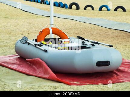 Bateau de sauvetage gonflable. Bateau gonflable gris sur la plage dans le sable Banque D'Images