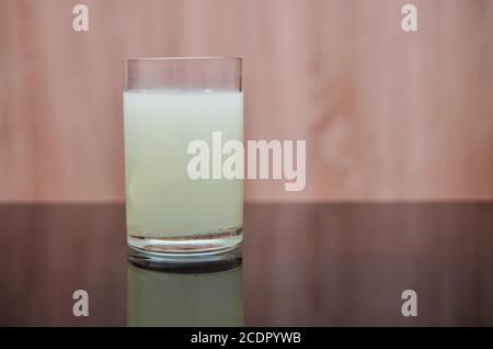 le comprimé effervescent se dissout dans un verre d'eau sur un table noire Banque D'Images