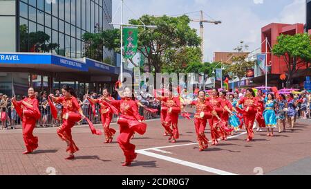 Les femmes chinoises en costumes rouge vif, dansant dans la rue avec des foulards et des tambours de taille. Tauranga, défilé de Noël en Nouvelle-Zélande, 11/30/2019 Banque D'Images