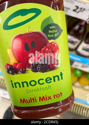 Viersen, Allemagne - août 9. 2020: Voir à la main tenant une bouteille innocente de jus de fruits de multivitamines dans le supermarché allemand Banque D'Images