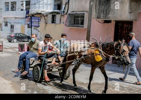 Gaza, la bande de Gaza, Palestine. 29 août 2020. Les Palestiniens ont une charrette tirée par des chevaux dans le camp de réfugiés de Jabalia, dans le nord de la bande de Gaza, le 29 août 2020, pendant la fermeture du secteur palestinien en raison de l'augmentation des cas de coronavirus. La bande de Gaza fait l'objet d'un confinement à l'échelle nationale à partir d'août 25, après la découverte des premiers cas de SRAS - le coronavirus COV-2 responsable de la COVID-19. Credit: Mahmoud Issa/Quds Net News/ZUMA Wire/Alay Live News Banque D'Images