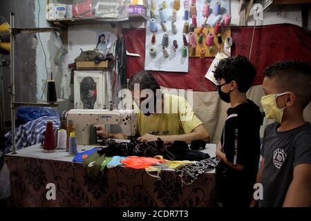 Gaza. 29 août 2020. Le tailleur palestinien Mohammed Awadallah fait des masques de visage lors de son atelier au camp de réfugiés de Shati à Gaza, le 29 août 2020. Credit: Rizek Abdeljawad/Xinhua/Alamy Live News Banque D'Images