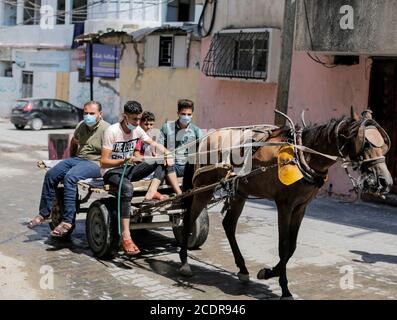 Gaza, la bande de Gaza, Palestine. 29 août 2020. Les Palestiniens ont une charrette tirée par des chevaux dans le camp de réfugiés de Jabalia, dans le nord de la bande de Gaza, le 29 août 2020, pendant la fermeture du secteur palestinien en raison de l'augmentation des cas de coronavirus. La bande de Gaza fait l'objet d'un confinement à l'échelle nationale à partir d'août 25, après la découverte des premiers cas de SRAS - le coronavirus COV-2 responsable de la COVID-19. Credit: Mahmoud Issa/Quds Net News/ZUMA Wire/Alay Live News Banque D'Images