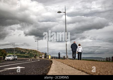 Visite de Greystones. Promenade de la mer. Marche et exercices. Vieux couple marchant le long de la mer. Banque D'Images
