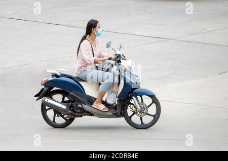 SAMUT PRAKAN, THAÏLANDE, JUL 03 2020, une femme avec le masque du visage, se déplace en moto dans la rue. Banque D'Images