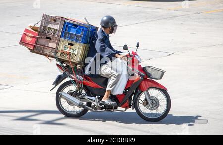 SAMUT PRAKAN, THAÏLANDE, JUL 23 2020, UN homme transportant un tas de caisses en plastique sur une moto. Banque D'Images
