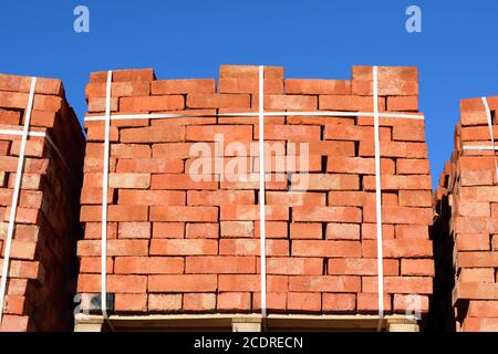 Des briques rouges superposés en cubes. Les briques de l'entrepôt. Produits de stockage briqueterie Banque D'Images