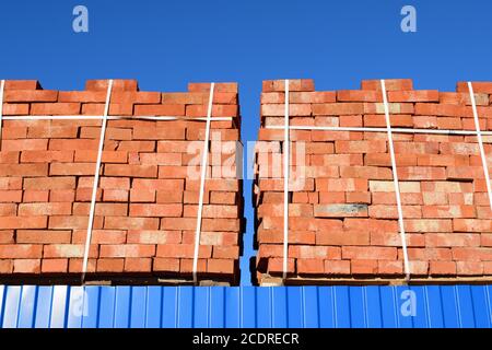 Des briques rouges superposés en cubes. Les briques de l'entrepôt. Produits de stockage briqueterie Banque D'Images