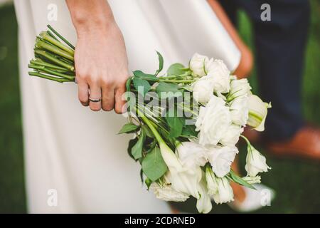 Mariage bouquet de roses blanches à la main de la mariée Banque D'Images