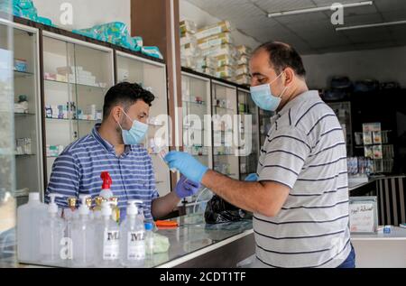 Gaza, Palestine. 29 août 2020. Les pharmaciens de réfugiés palestiniens portent un masque facial par mesure de précaution, lors du confinement de la Covid 19.la bande de Gaza est soumise à un confinement national depuis le 25 août, après la détection des premiers cas de SRAS-COV-2. Crédit : Mahmoud Issa/SOPA Images/ZUMA Wire/Alay Live News Banque D'Images