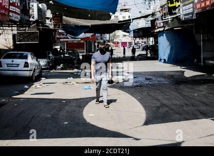 Gaza, Palestine. 29 août 2020. Un palestinien qui passe devant des magasins fermés dans le camp de Jabalia, pendant le confinement de la bande de Gaza en 19.la bande de Gaza est soumise à un confinement national depuis le 25 août après la détection des premiers cas de SRAS-COV-2. Crédit : Mahmoud Issa/SOPA Images/ZUMA Wire/Alay Live News Banque D'Images