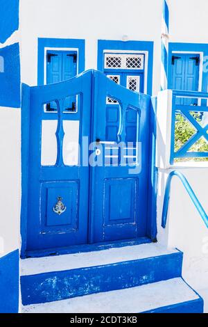 Maison grecque traditionnelle en pierre, porte bleue et volets de fenêtre, île de Santorini, Grèce. Banque D'Images