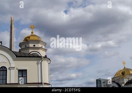 Brest, Bélarus - 18 avril 2020 : l'obélisque de la forteresse de Brest sur fond d'église orthodoxe et de ciel nuageux. Banque D'Images