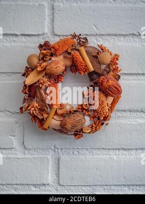 Magnifique couronne de fleurs suspendue sur un mur de briques blanches Banque D'Images