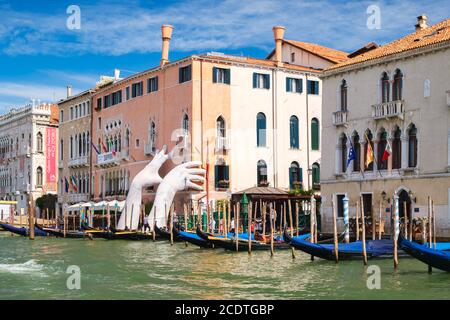 VENISE,ITALIE - JUILLET 26,2017 : mains géantes soutenant un ancien palais à côté du Grand Canal, une œuvre d'art de Lorenzo Quinn Banque D'Images