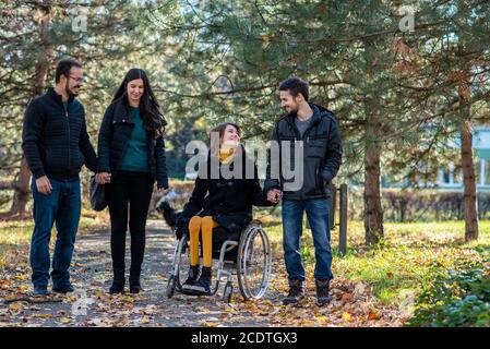 Jeune femme handicapée avec des amis dans un parc Banque D'Images