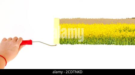Une personne peint un paysage avec des fleurs jaunes sur un mur blanc avec une brosse rotative Banque D'Images