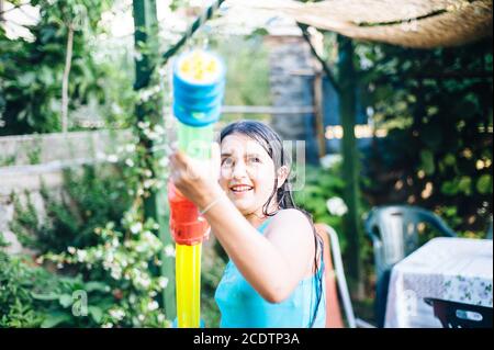 les enfants jouent dans le jardin avec des fusils et des fusils à eau un jour d'été ensoleillé Banque D'Images