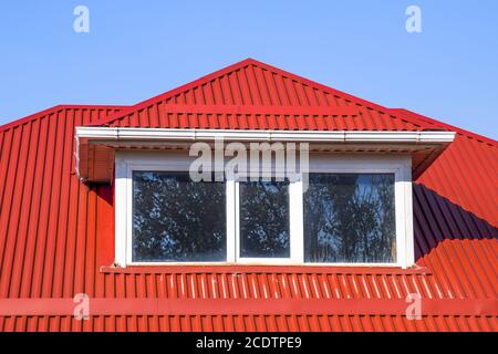 Chambre avec fenêtres en plastique et un toit en tôle ondulée de rouge Banque D'Images