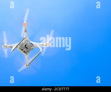Drone DJI Phantom 4 en vol. Quadrocopter contre le ciel bleu Banque D'Images