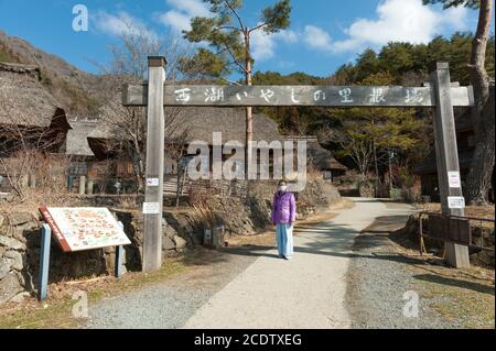 Femme touriste portant un masque chirurgical à l'entrée de l'ancien village japonais Saiko Iyashino-Sato Nenba (village de guérison). Banque D'Images