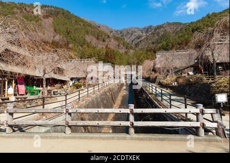 Maisons en toit de chaume sur le bord d'une rivière sèche avec clôture en bois dans l'ancien village japonais appelé Saiko Iyashino-Sato Nenba. Banque D'Images