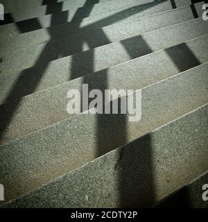 Ombre d'une grille de fenêtre sur les escaliers dans un escalier Banque D'Images