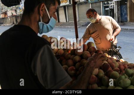 Gaza. 29 août 2020. Un palestinien portant un masque facial achète des fruits sur un marché de la ville de Gaza, le 29 août 2020. Credit: Rizek Abdeljawad/Xinhua/Alamy Live News Banque D'Images