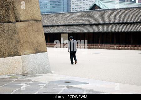 Homme marchant devant le guardhouse Hyakunin-bansho, East Gardens, Palais impérial de Tokyo, 2009 Banque D'Images