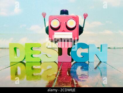 La tête du robot rétro rouge sur le mot DESIGN sur vieux plancher en bois RÉFLEXION WIT Banque D'Images