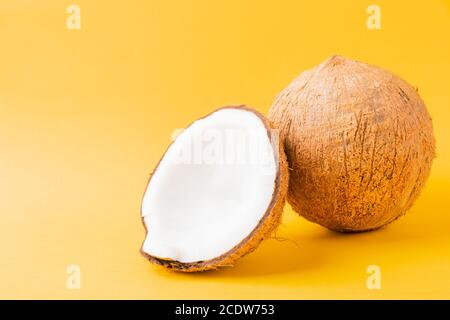 Happy Coconuts concept de jour, noix de coco fraîche et demi-noix de coco, prise studio isolée sur fond jaune Banque D'Images