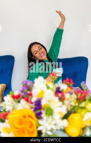 Bonne belle jeune femme avec son arrangement de fleur dans votre accueil Banque D'Images
