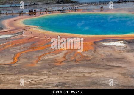 La grande et dynamique Grand Prismatic Springs dans le parc national de Yellowstone avec des touristes non identifiables sur un passage. Banque D'Images