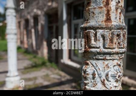 Détail de l'ancienne colonne de style grec d'appui métallique au mur de brique Banque D'Images