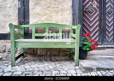 banc vert en face d'une maison à colombages dans le Vieille ville de Quedlinburg Banque D'Images