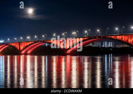 Krasnoyarsk, Russie. Vue de nuit sur le pont communal de Krasnoyarsk avec rétroéclairage rouge et rivière Yenisey. Banque D'Images