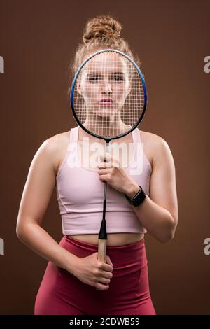 Jeune joueuse de tennis tenant une raquette devant elle face isolée Banque D'Images
