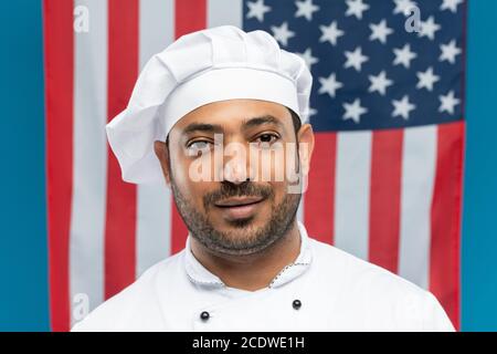 Jeune chef de restaurant à succès en uniforme blanc debout avant de l'appareil photo Banque D'Images