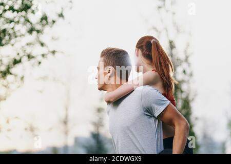 femme sur le dos hommes à l'extérieur marcher amusant style de vie Banque D'Images