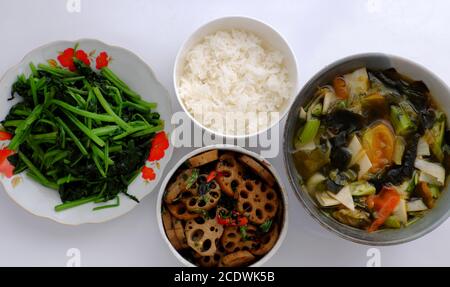 Repas vegan tous les jours, plat de cuisson en tranches de lotus avec sauce, soupe de légumes, bol de riz, épinards frits, simple plat végétarien vietnamien pour le régime Banque D'Images