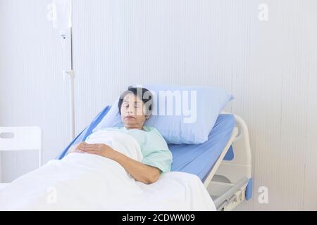 Les femmes asiatiques âgées dorment dans un lit d'hôpital. Banque D'Images
