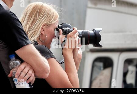 Berlin, Allemagne, 29 août 2020 : une jeune femme aux cheveux blonds et au visage pincé prend des photos avec sa caméra de la marche de protestation contre corona Banque D'Images