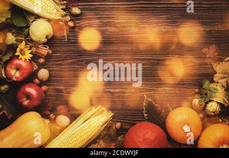 Fond de Thanksgiving, concept de récolte d'automne alimentaire. Table rustique avec pommes, citrouilles, noix, raisins et maïs sur table sombre avec espace de copie, top vie Banque D'Images