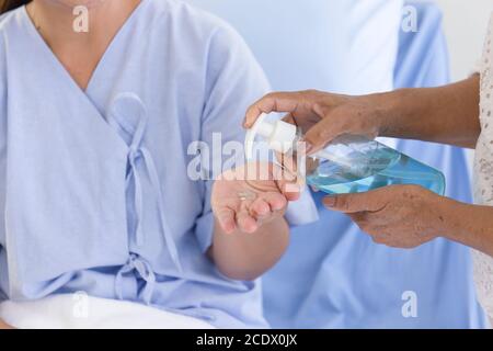 La main qui appuie sur la bouteille de gel d'alcool pour les malades pour se laver les mains. Banque D'Images
