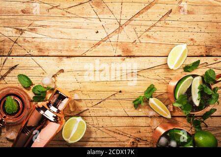 Cocktail moscovite mule en tasse de cuivre avec citron vert, bière au gingembre, vodka et menthe. Table en bois, vue de dessus, espace de copie Banque D'Images