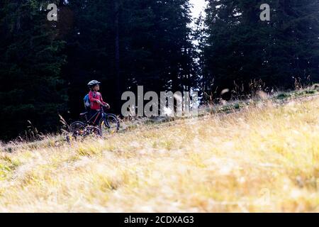 jeune garçon en vélo sur le chemin entouré d'herbe Banque D'Images