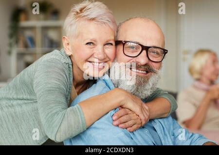 Portrait d'un couple senior heureux qui s'embrasse et sourit à l'appareil photo Banque D'Images