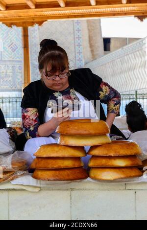 Femme vendant du pain sur le marché. Samarkand, Ouzbékistan Banque D'Images