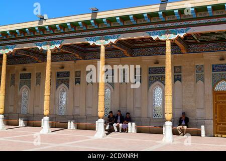 Personnes assises à l'ombre de la voûte de la mosquée Hazrat Khizr. Samarkand, Ouzbékistan Banque D'Images