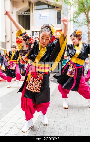 Gros plan de l'équipe japonaise de danseurs de yosakoi dansant avec une jeune danseuse devant le spectateur, au festival Kyusyu Gassai, Kumamoto. Banque D'Images